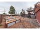 Backyard featuring a garden with raised beds and a deck with stairs on a brick house at 889 Douglas Dr, Denver, CO 80221