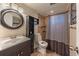 Bathroom featuring a modern vanity, tiled shower with a striped curtain, and a round mirror at 889 Douglas Dr, Denver, CO 80221