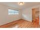 Bright bedroom features hardwood floors, neutral paint, and natural light from the window at 889 Douglas Dr, Denver, CO 80221
