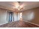 Neutral bedroom with a ceiling fan, closet, and an open doorway leading to another room at 889 Douglas Dr, Denver, CO 80221
