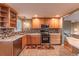 Updated kitchen featuring wooden cabinets, stainless steel appliances, and stylish tiled backsplash at 889 Douglas Dr, Denver, CO 80221