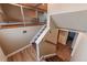 A staircase that features a light-colored wall, wood railings, and carpeted stairs at 889 Douglas Dr, Denver, CO 80221