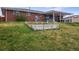 Backyard with a brick home, patio, hot tub, grassy area, and garden bed at 4713 S Robb St, Littleton, CO 80127