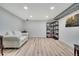 Basement area with wood-look flooring, couch, shelving, and recessed lighting at 4713 S Robb St, Littleton, CO 80127
