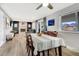 Open-concept dining area with hardwood floors flows into a living area with a fireplace and large windows at 4713 S Robb St, Littleton, CO 80127