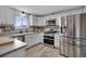 Bright kitchen with white cabinets, stainless steel appliances, and a view of the mountains at 4713 S Robb St, Littleton, CO 80127