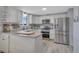 Bright kitchen featuring white cabinets, stainless steel appliances, and modern countertops at 4713 S Robb St, Littleton, CO 80127