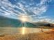 Scenic lake view with sunlight reflecting off the water, framed by mountains and a sandy beach at 4713 S Robb St, Littleton, CO 80127