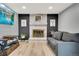 Comfortable living room features a gray couch, brick fireplace, a large television, and hardwood flooring at 4713 S Robb St, Littleton, CO 80127