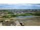 Aerial view of a community with green spaces, a pond, and homesites, offering a picturesque and serene environment at 15523 E 117Th Ave, Commerce City, CO 80022