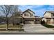 Charming two-story home with a three-car garage, mature landscaping, and a welcoming front porch at 15523 E 117Th Ave, Commerce City, CO 80022