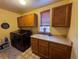 Spacious laundry room with modern washer/dryer, utility sink, storage cabinets, and window at 15523 E 117Th Ave, Commerce City, CO 80022