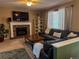 Inviting living room with a fireplace, large TV, and comfortable seating, perfect for relaxation and entertainment at 15523 E 117Th Ave, Commerce City, CO 80022