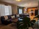 Comfortable living room featuring a sectional sofa, wood floors, and an open connection to the kitchen at 15523 E 117Th Ave, Commerce City, CO 80022