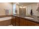 Well-lit bathroom with dual vanity, granite counters, a soaking tub, and a glass shower at 22820 E Chenango Ave, Aurora, CO 80015