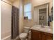 Well-maintained bathroom with vanity, toilet, shower with curtain and neutral decor at 22820 E Chenango Ave, Aurora, CO 80015