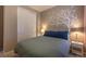 Comfortable bedroom featuring a white tree mural, plush bedding, and a closet for ample storage at 22820 E Chenango Ave, Aurora, CO 80015