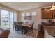 Bright dining room features sliding glass door, modern light fixture, and stylish table with seating for six at 22820 E Chenango Ave, Aurora, CO 80015