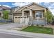 Attractive home showcasing a cozy front porch with stone accents and a well-manicured lawn at 22820 E Chenango Ave, Aurora, CO 80015