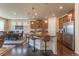 Open kitchen concept featuring a large island, bar stool seating, stainless steel appliances, and wood flooring at 22820 E Chenango Ave, Aurora, CO 80015