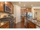 Updated kitchen with stainless appliances, granite countertops, wood cabinets, and hardwood flooring at 22820 E Chenango Ave, Aurora, CO 80015