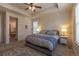 Comfortable main bedroom featuring a tray ceiling, neutral decor, and an ensuite bathroom at 22820 E Chenango Ave, Aurora, CO 80015