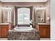 Luxurious bathroom featuring a marble-clad tub, and vanities and bright natural light at 3143 Elmira St, Denver, CO 80238