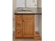 Bathroom vanity with wood cabinets, dark countertop, and stainless steel sink at 3143 Elmira St, Denver, CO 80238