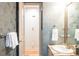 Bathroom with patterned wallpaper, marble countertop vanity and white trim at 3143 Elmira St, Denver, CO 80238