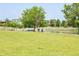 Beautiful community park with a pond, lush green lawn, mature trees and walking path at 3143 Elmira St, Denver, CO 80238