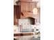 Close up of a kitchen with custom cabinets and matching hood vent at 3143 Elmira St, Denver, CO 80238