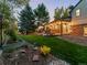 Expansive backyard with mature trees, a patio, an outdoor kitchen, and a well-maintained lawn at 7668 S Locust St, Centennial, CO 80112