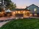 Cozy backyard with a stone patio, outdoor kitchen, string lights, and lush green lawn at 7668 S Locust St, Centennial, CO 80112