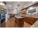 Bright kitchen with island, stainless appliances, hardwood floors, and a view to the living room at 7668 S Locust St, Centennial, CO 80112