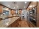 Well-lit kitchen with stainless steel appliances, granite counters, and an adjacent dining area at 7668 S Locust St, Centennial, CO 80112