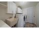 Laundry room features utility sink, cabinetry and washer and dryer at 7668 S Locust St, Centennial, CO 80112