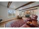 Open living room with fireplace, exposed beams, large windows and view to the second floor at 7668 S Locust St, Centennial, CO 80112
