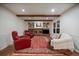 Cozy living room with a brick fireplace, hardwood floors, comfortable seating, and built-in bookshelves at 7668 S Locust St, Centennial, CO 80112