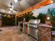 Covered outdoor kitchen featuring a built-in grill, stone accents, and ceiling fan at 7668 S Locust St, Centennial, CO 80112