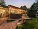 Charming outdoor kitchen and patio featuring a stone surround, bar seating, and integrated lighting at 7668 S Locust St, Centennial, CO 80112