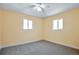 A sunny bedroom with two windows offering lots of natural light and soft gray carpet at 862 N Uvalda St, Aurora, CO 80011