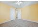 A bright bedroom featuring neutral walls, trim and carpet, and three doors at 862 N Uvalda St, Aurora, CO 80011