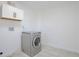 This laundry room features a front load washer and plenty of cabinet space at 862 N Uvalda St, Aurora, CO 80011