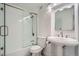 Compact bathroom featuring a tub and shower combination, pedestal sink, and bright lighting at 1625 Larimer St # 1104, Denver, CO 80202