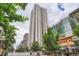 Contemporary high-rise building with modern design and surrounding urban landscape with mature trees and street-level businesses at 1625 Larimer St # 1104, Denver, CO 80202