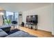 Bright living room featuring hardwood floors, a cozy chair, and large windows with city views at 1625 Larimer St # 1104, Denver, CO 80202
