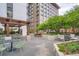 Outdoor patio area with dining tables, lush greenery, a built-in grill, and attractive pergola at 1625 Larimer St # 1104, Denver, CO 80202