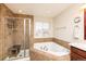 Modern bathroom with shower, tub, and tile surround at 23549 E Ottawa Pl, Aurora, CO 80016