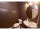 Stylish powder room featuring a pedestal sink, toilet, and decorative lighting at 23549 E Ottawa Pl, Aurora, CO 80016