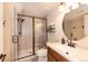 Bathroom features walk-in shower, wood vanity, a round mirror, and neutral tones at 23549 E Ottawa Pl, Aurora, CO 80016